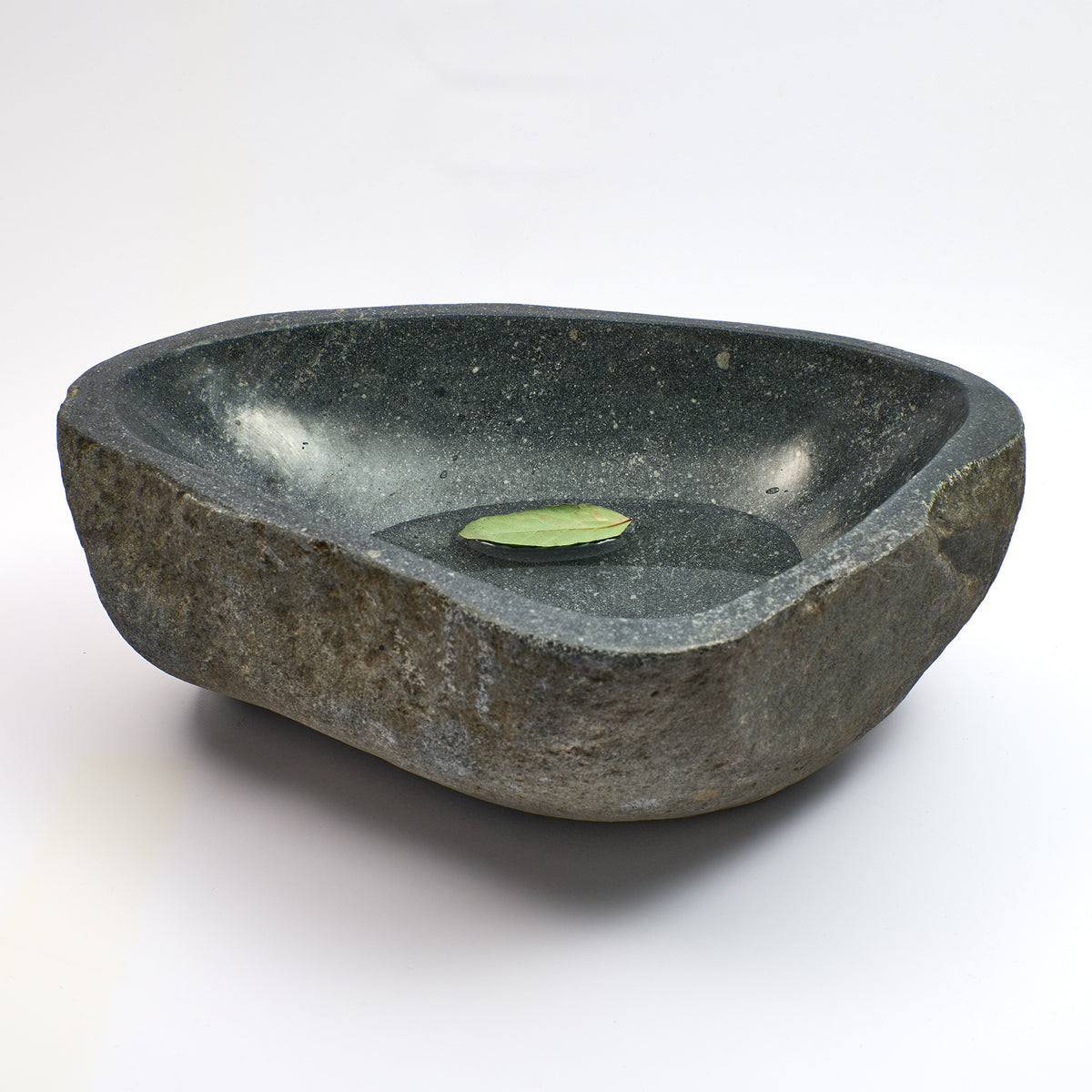Schale aus Flussstein, dunkle graue Schale mit schrägem Rand und kleinem Blatt, welches im Wasser schwimmt