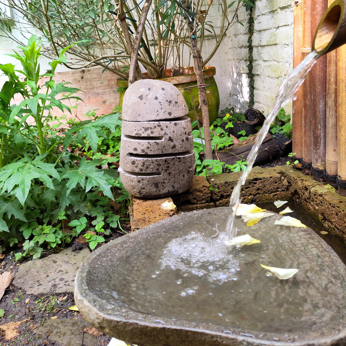 Schale aus Flussstein mit Wasserlauf, runde graue Schale am Gartenbrunnen