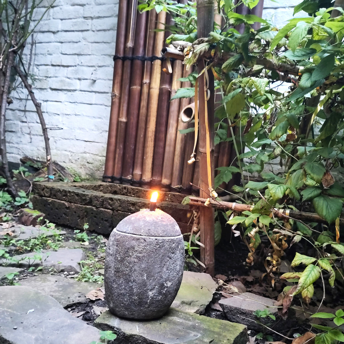 Stein-Öllampe aus Naturstein mit brennender Flamme und Docht