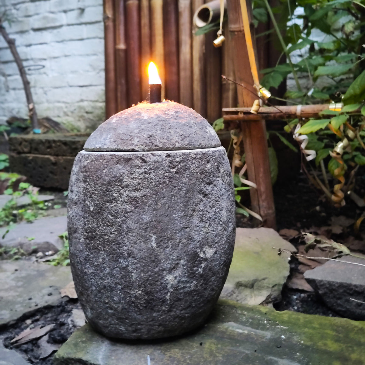 Öllampe aus Naturstein mit brennender Flamme und Docht